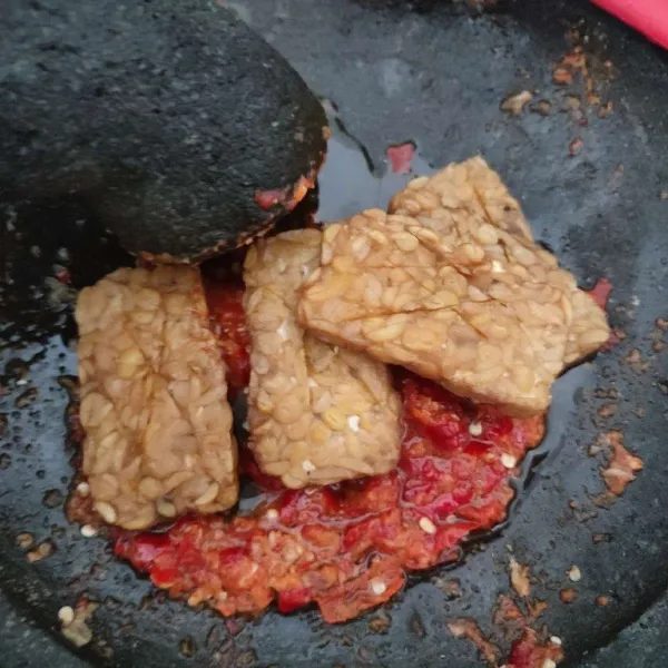 Penyetkan tempe ke atas sambal kencur. 
Lalu ratakan.