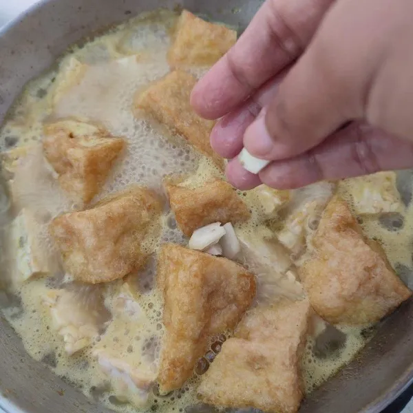 Masukkan irisan kencur, masak hingga layu.