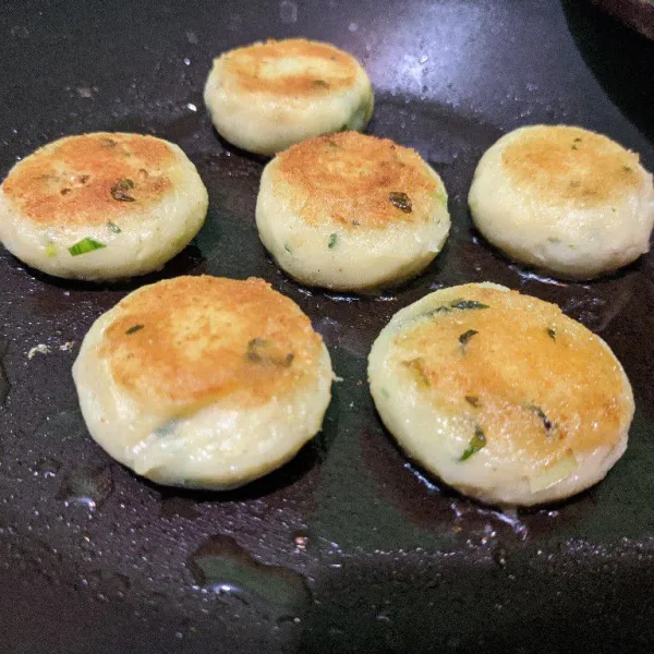 Panaskan sedikit minyak di atas teflon, panggang kentang yang telah dibentuk hingga golden brown menggunakan api sedang. Balik sisi satunya, masak hingga matang juga.