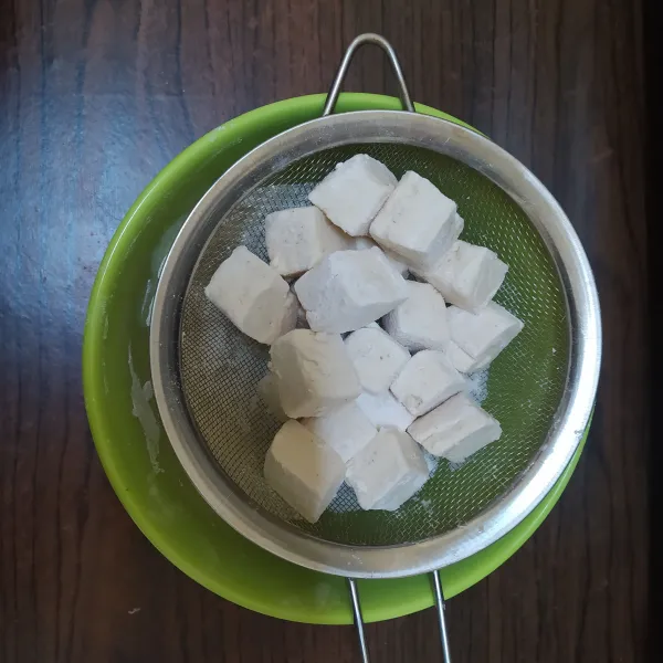 Potong- potong tahu, lalu campurkan dengan tepung serba guna.