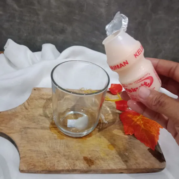 Siapkan gelas, masukan minuman yakult.