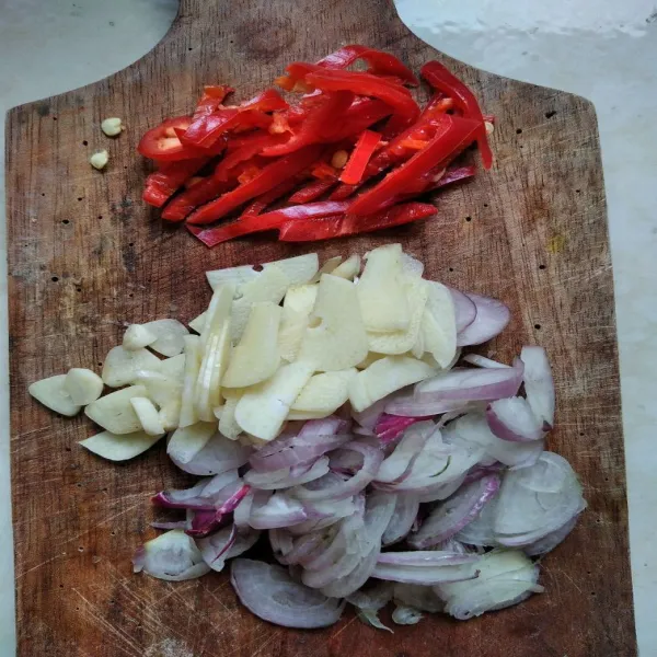 Rajang bawang merah dan bawang putih, lalu iris serong cabai besar.
