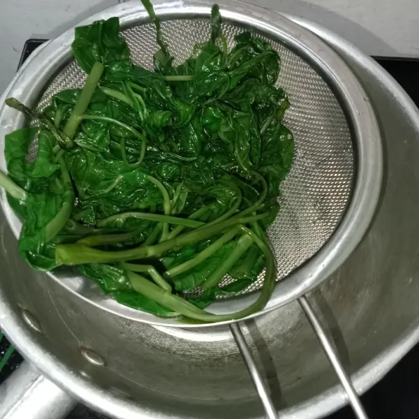 Siram kangkung dengan air mengalir lalu tiriskan.