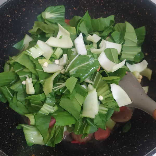 Masukkan irisan daun bawang prei dan pokcoy, tumis hingga sayur layu.