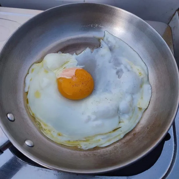 Pecahkan telur, taburi dengan merica bubuk. Masak sampai bagian putih matang atau kuning telur ½ matang.