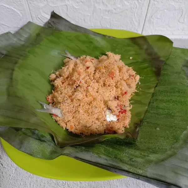 Siapkan daun pisang. 
Taruh bumbu kelapa, ikan asin dan bumbu kelapa lagi.