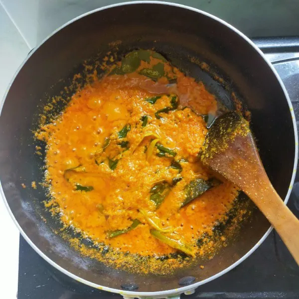 Tumis bumbu halus, daun jeruk, serai dan daun kunyit hingga matang dan harum.