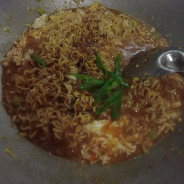 Setelah mie setengah matang, masukan telur, bumbu mie instan, kecap, garam dan kaldu serta daun bawang. Aduk rata dan masak sampai mie matang