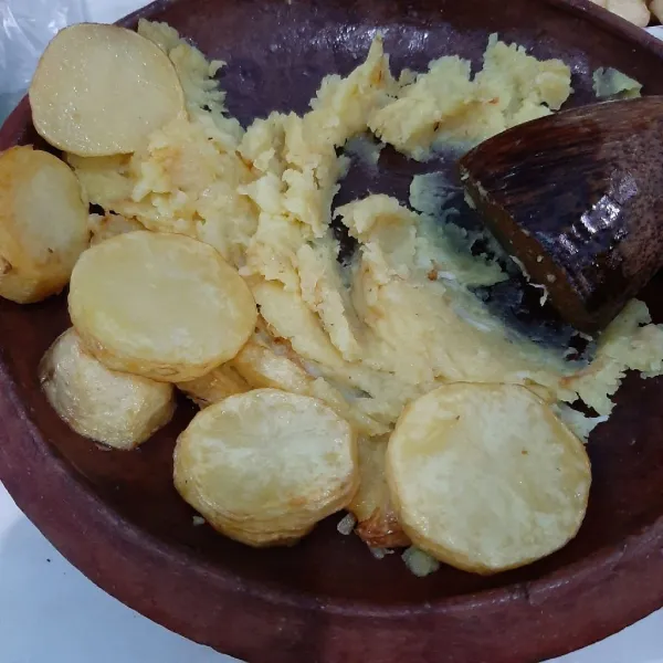 Haluskan kentang dan bawang putih.
