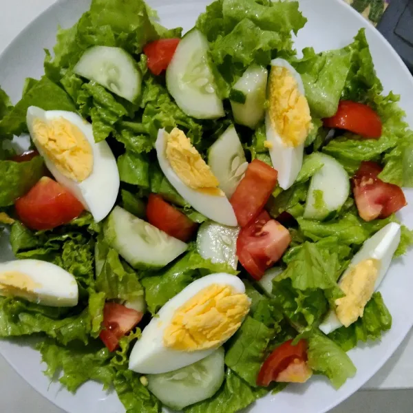 Tata sayuran dalam piring berserta potongan telur rebus