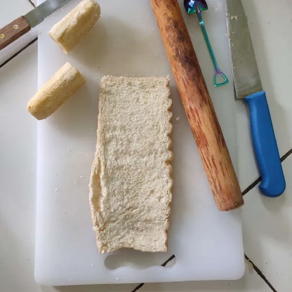 Pipihkan roti tawar dengan menggunakan rolling pin.