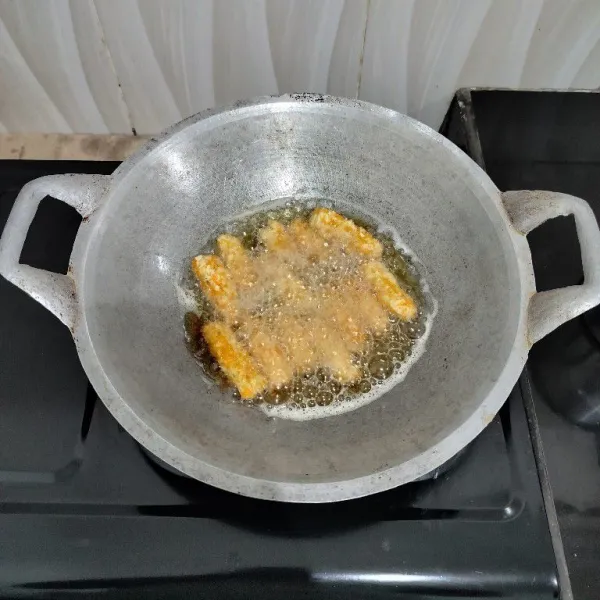 Setelah itu goreng stik tempe dalam minyak panas hingga matang, lalu angkat dan tiriskan.