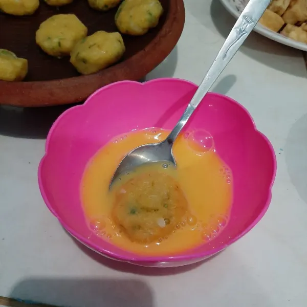 Kocok lepas telur dan celupkan perkedel di kocokan telur. Kemudian goreng hingga cokelat keemasan, lalu angkat dan sajikan.