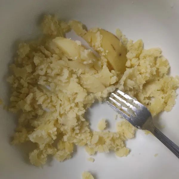 Haluskan kentang menggunakan garpu.