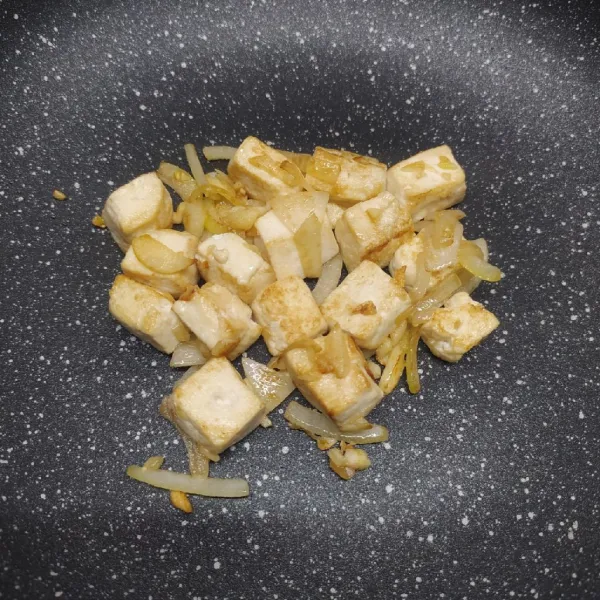 Masukkan tahu dan masak sampai tahu sedikit kecokelatan.