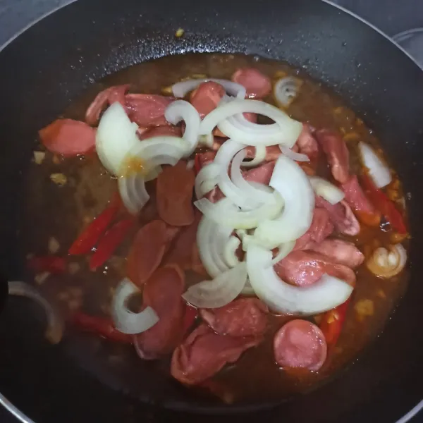 Masukkan bawang bombay dan sosis.