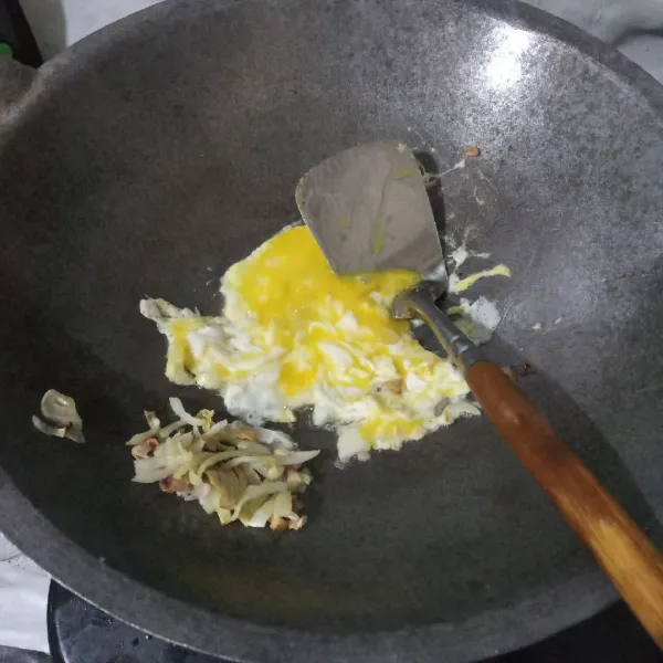 Pecahkan telur di wajan, lalu buat orak-arik.