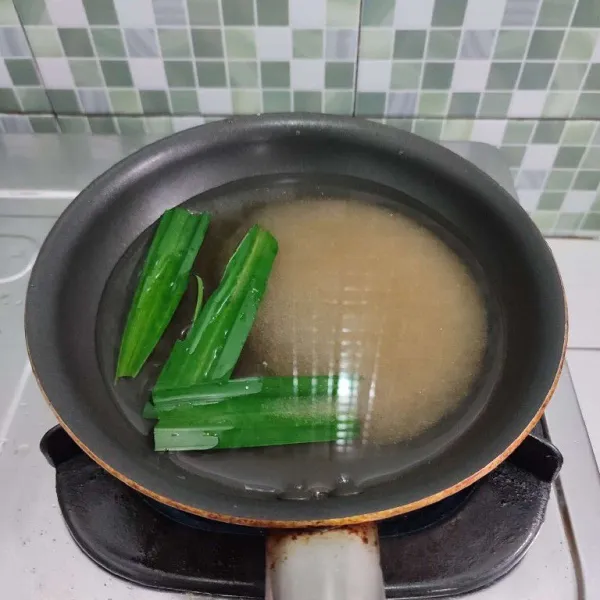 Rebus air bersama gula dan daun pandan hingga larut, tidak perlu sampai mendidih, kemudian biarkan hangat. 
Buang daun pandannya.