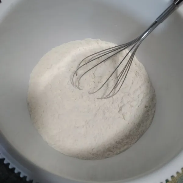 Campur tepung terigu dan ragi instan dalam wadah, aduk hingga rata.
