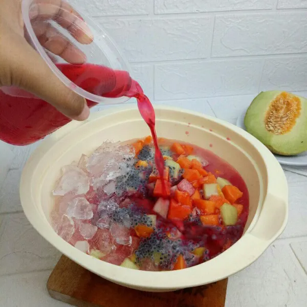 Larutkan serbuk frambozen dengan 400 ml air, lalu tuang ke wadah buah, aduk rata dan tes rasa.