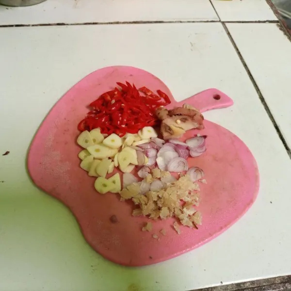 Iris tipis bawang merah putih dan cabe merah besar. Haluskan kemiri yang telah digoreng sebelumnya.