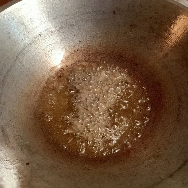 Rendam ikan teri selama 5 menit dengan air panas, kemudian bilas. 
Panaskan minyak goreng, goreng ikan teri hingga kering. 
Sisihkan.