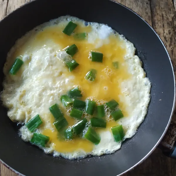 Panaskan minyak di wajan teflon, tuang adonan telur, masak sampai sisi bawahnya matang.