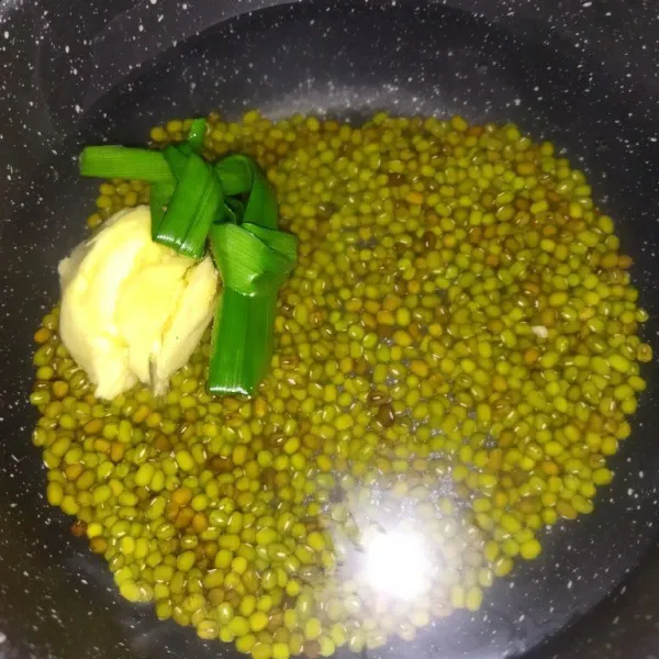 Masak 550 ml air hingga mendidih, lalu masukkan kacang hijau, daun pandan dan jahe, lalu tutup pancinya, setelah mendidih, rebus kacang hijau selama 5 menit, lalu matikan api, diamkan hingga 30 menit, pancinya masih ditutup.