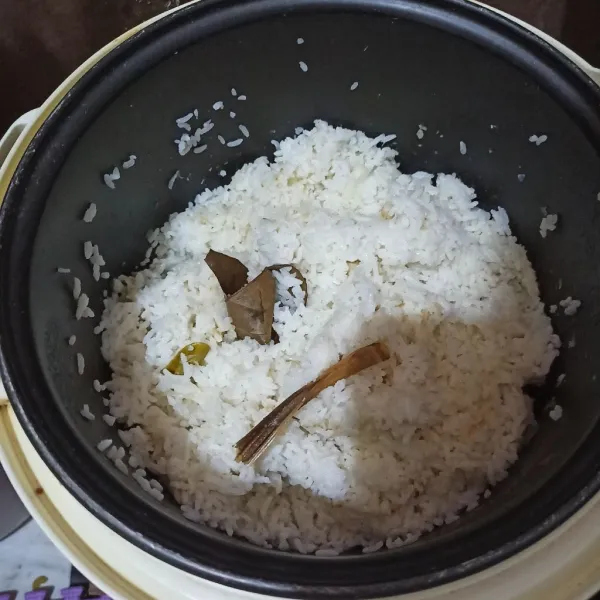 Masukkan beras yang sudah dicuci ke magic com, beri santan, air , serai, daun salam, daun jeruk, garam aduk rata. Lalu masak seperti biasa. Setelah masak, ambil nasi lalu tunggu hingga hangat/dingin suhu ruang