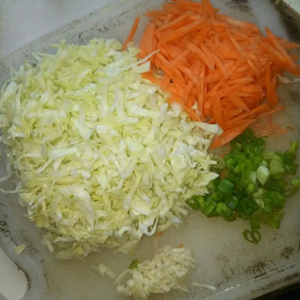 Cuci bersih dan iris halus kol, wortel dan daun bawang. Bawang putih dicincang halus.