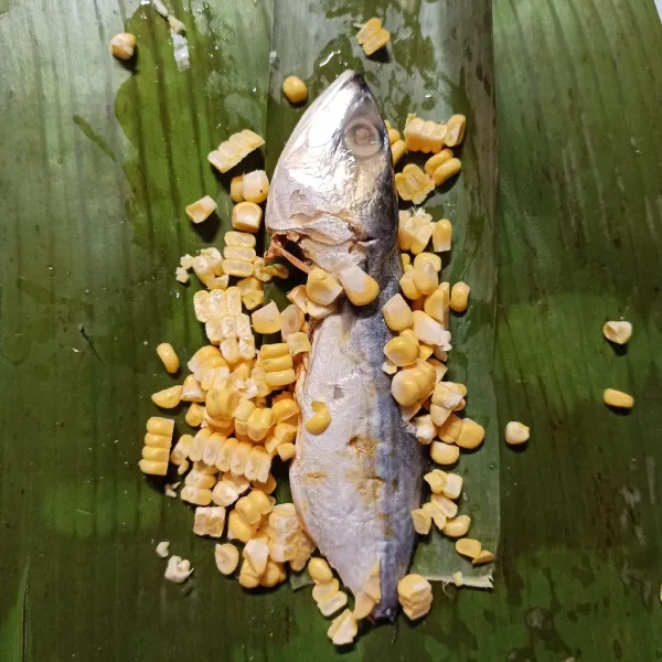 Sisir jagung, letakkan di atas daun pisang, beri ikan peda.
