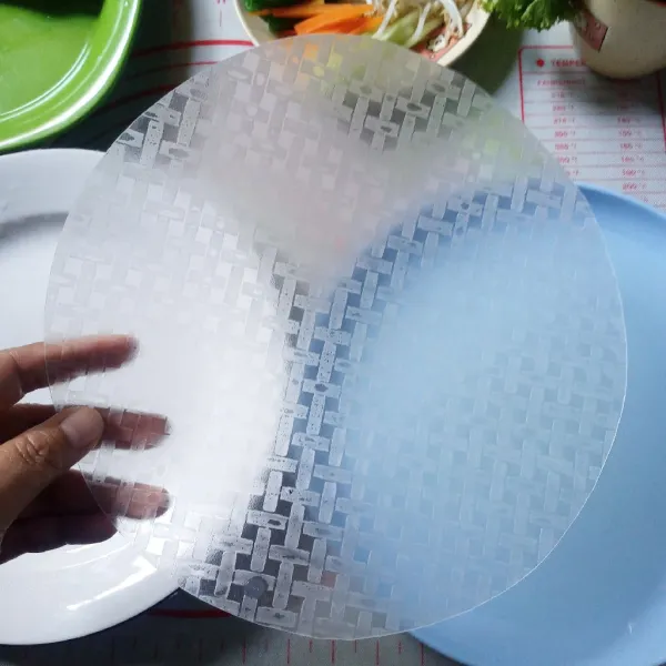 Siapkan selembar rice paper. Celupkan ke air matang lalu letakkan di piring.