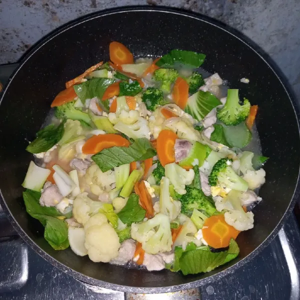 Tambahkan air, gula garam dan lada bubuk. Aduk rata. Masak sampai mendidih. Kemudian masukkan sayuran. Masak sampai mendidih.
