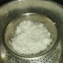 Siapkan kelapa parut setengah tua, beri garam, aduk rata, lalu kukus selama 10 menit.
