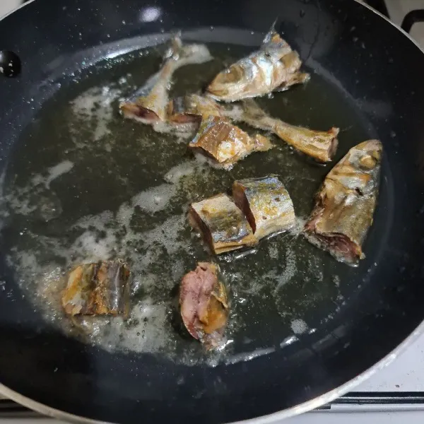 Cuci bersih ikan asin, rendam dalam air panas sebentar lalu tiriskan. 
Goreng ikan asin hingga cokelat, tiriskan.