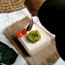 Tata buah pepaya dan kiwi di atas puding.
