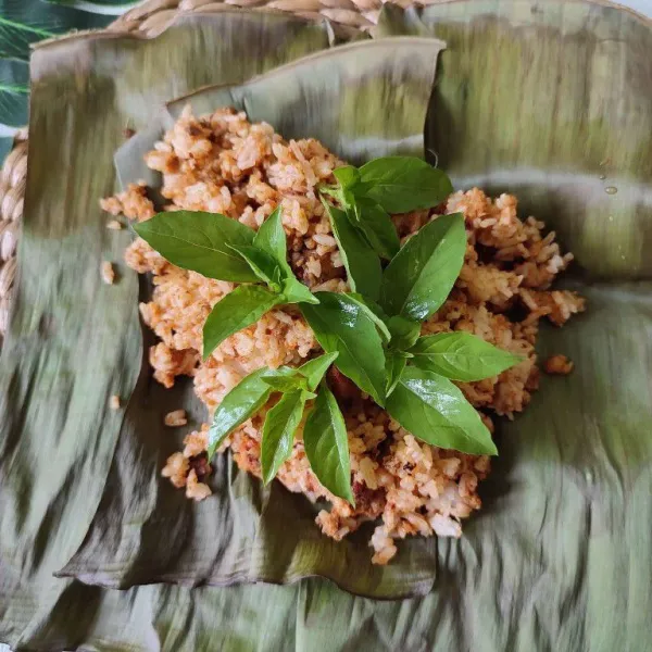 Tata nasi di atas daun pisang, lalu beri daun kemangi di atasnya.