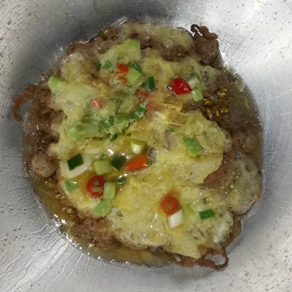Panaskan minyak, lalu tuang telur agak tinggi dari permukaan minyak hingga membentuk telur keriting. Goreng hingga permukaan bawah matang.