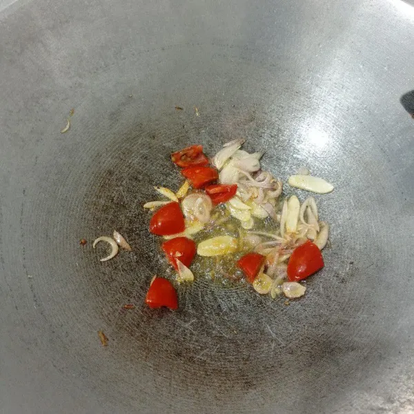 Tumis bawang putih dan merah sampai harum, kemudian masukkan tomat. Masak sampai tomat layu