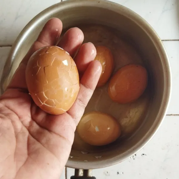 Ambil telur yang telah direbus matang, kemudian retak-retakan kulit telur dengan bantuan ujung garpu atau sendok, kemudian sisihkan.
