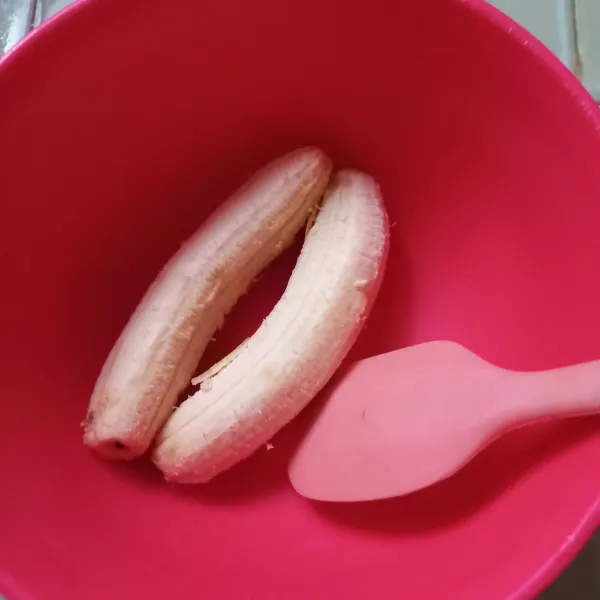 Siapkan dua buah pisang ambon lumut, buka kulitnya, kemudian haluskan dengan sendok.