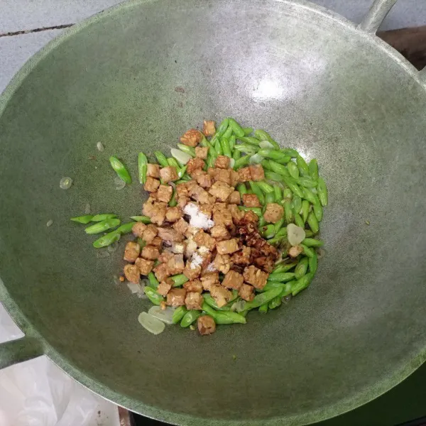 Masukkan tempe. Tambahkan secukupnya merica bubuk, garam, gula, kecap, dan kaldu bubuk. Aduk-aduk perlahan. Masak sebentar hingga tumis matang dan bumbu meresap (buncis jangan terlalu empuk agar tekstur renyahnya masih ada). Sajikan.
