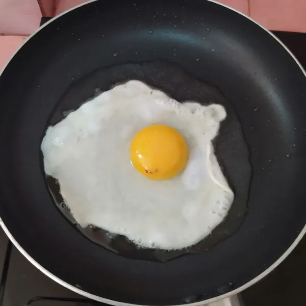Panaskan pan anti lengket, beri sedikit minyak. 
Buat sunny side egg : pecahkan telur, tunggu hingga setengah matang, tambahkan sedikit air di pinggir telur agar pinggiran telur tidak gosong. 
Beri sejumput lada dan garam.