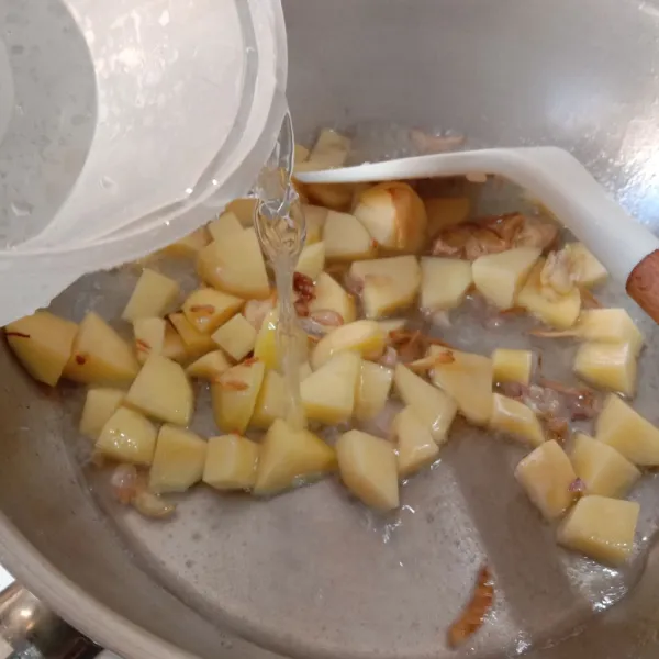 Masukkan potongan kentang dan beri air secukupnya, kemudian masak sampai kentang hampir empuk dan air berkurang.