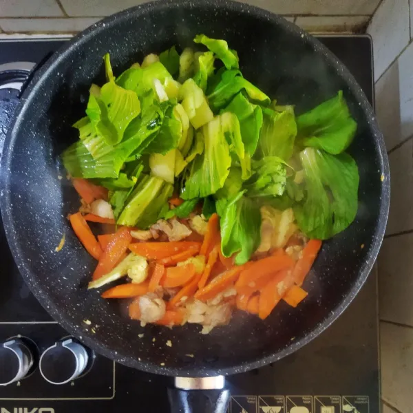Masukan air, wortel dan kembang kol, masak hingga setengah layu. Tambahkan pakcoy, saus tiram dan kecap asin biarkan mendidih.