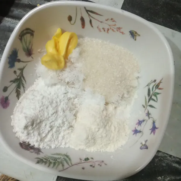 Campurkan kelapa parut, garam, margarin, gula pasir, vanili bubuk, tepung beras, dan tepung terigu, lalu aduk rata.