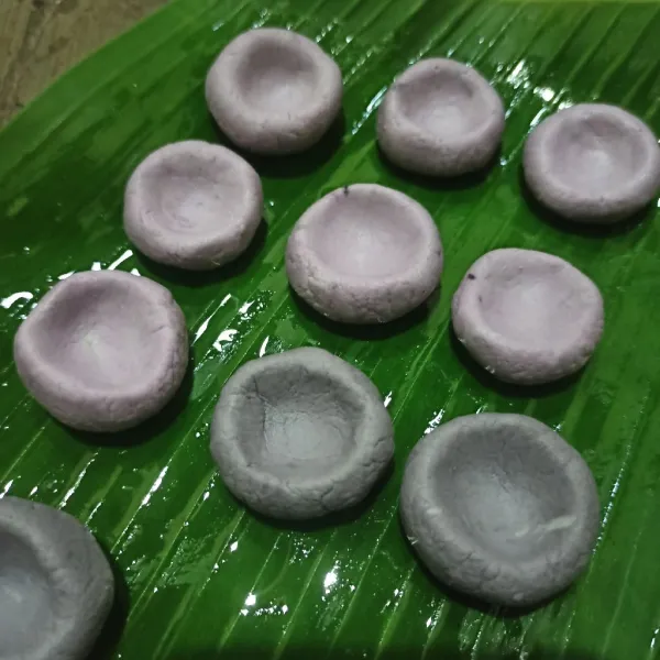 Ambil adonan bentuk lingkaran lalu tekan bagian tengahnya menggunakan jari, letakkan di daun pisang/ wadah yang sudah diolesi minyak.