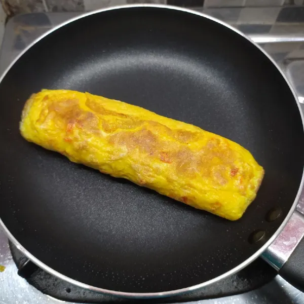 Masak dengan api kecil sampai telur matang sempurna di bagian dalamnya. Kemudian angkat dan potong-potong telur gulung, lalu sajikan.
