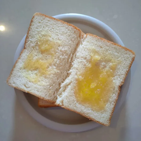 Olesi roti tawar dengan selai, kemudian tumpuk.