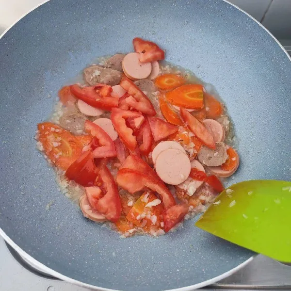 Ketika wortel mulai empuk, kemudian masukkan sosis, bakso, dan tomat. Masak hingga sosis matang.